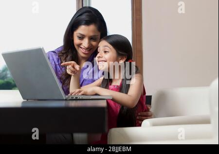 Mother and daughter having fun on a laptop Stock Photo