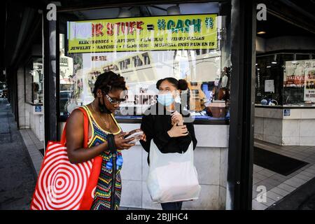 Los Angeles, United States. 23rd Apr, 2020. Pedestrians wear face masks as a protective measure standing in front of a supermarket during lockdown amid Coronavirus.USA Health Ministry recorded a total of 1.06M infections, death 61,361 and 123 recovered since the beginning of the outbreak. Credit: SOPA Images Limited/Alamy Live News Stock Photo