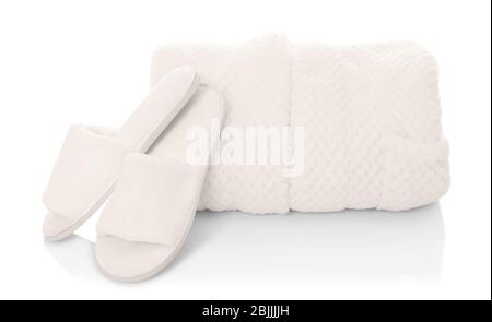 Folded bathrobe and bathing slippers on white background Stock Photo