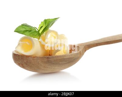 Wooden spoon with delicious butter curls and basil on white background Stock Photo