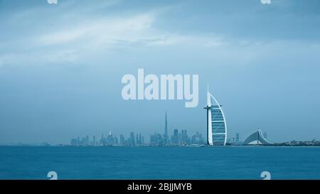 Viewing Dubai cityscape with Kumeirah coast and Downtown across the sea on a moody cloudy day. Dubai, United Arab Emirates. Stock Photo