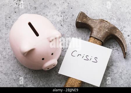 Note with text, piggy bank and hammer on the table, top view. Crisis concept Stock Photo