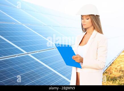 Female engineer developing project on installation of solar panels outdoors Stock Photo