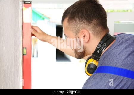 Worker repairing window in flat Stock Photo
