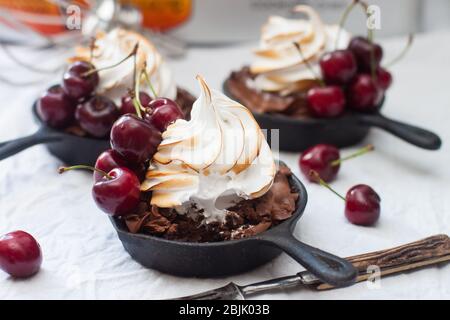 Mini tarts in iron skillets with oreo cookie dough, chocolate filling, whipped cream and fresh berries. Stock Photo