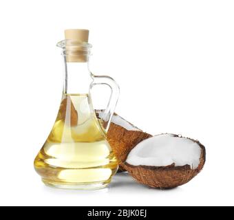 Ripe coconut and pitcher with oil on white background Stock Photo