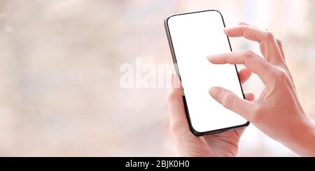 Female hand with smartphone, white blank screen with copy space. Stock Photo