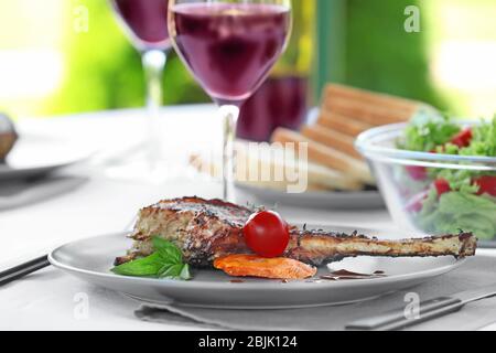 Plate with delicious rib and vegetables on table Stock Photo