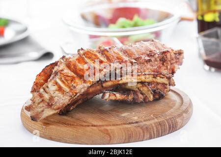 Delicious juicy ribs on wooden board Stock Photo