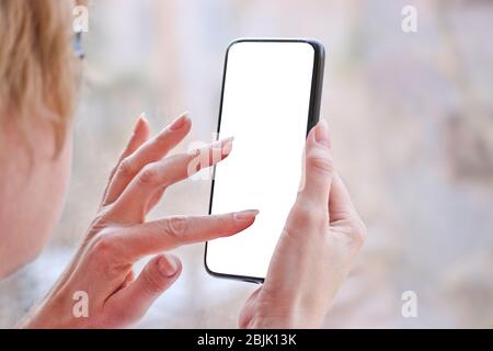 Female hand with smartphone, white blank screen with copy space. Stock Photo