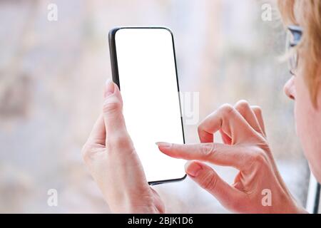 Female hand with smartphone, white blank screen with copy space. Stock Photo