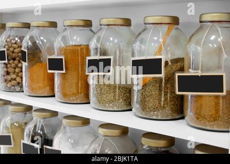 Different spices in jars on shelf Stock Photo