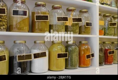Different spices in jars on shelves Stock Photo