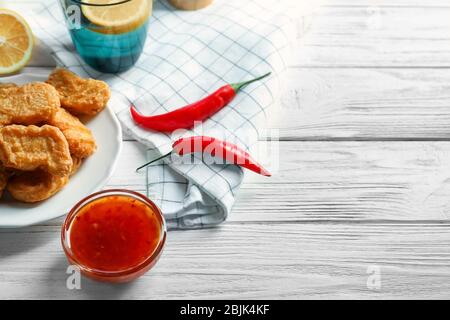 Chicken nuggets served with chili sauce on wooden table Stock Photo