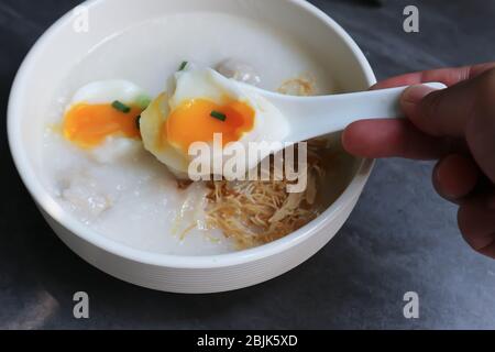 eating rice gruel, rice porridge or congee Stock Photo