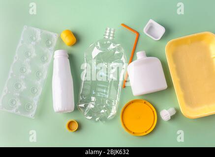 Recycled materials from different plastic on a green background. Zero waste concept. View from above Stock Photo
