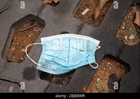 28.04.2020, Singapore, Republic of Singapore, Asia - A ditched protective face mask lies on the ground at a parking lot in the district of Ang Mo Kio. Stock Photo