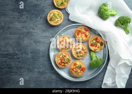 Composition with broccoli quiche tartlets on table Stock Photo