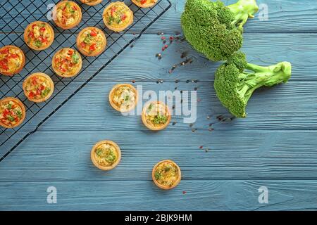 Composition with broccoli quiche tartlets on table Stock Photo