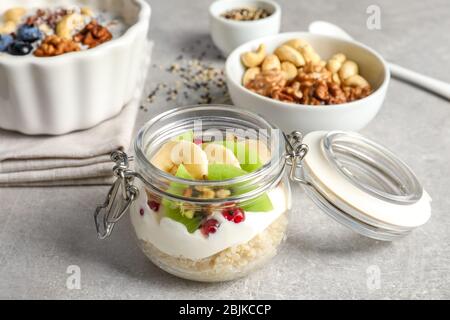 Tasty quinoa with fruits in jar on table Stock Photo