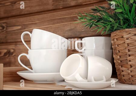 Clean cups on wooden shelf Stock Photo