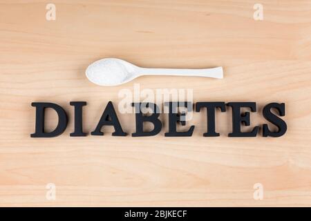 Word Diabetes and sugar in spoon on light background Stock Photo