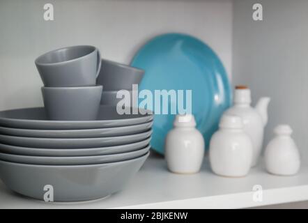 Ceramic dishware on white shelf indoors Stock Photo