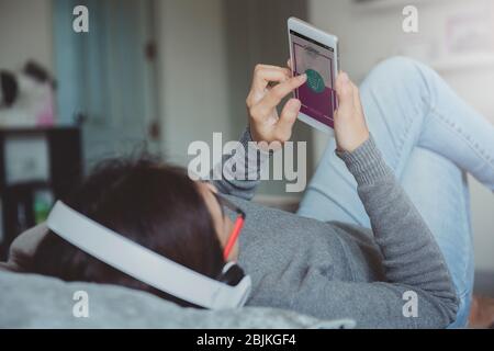 Young woman using smartphone buying online shopping while lying on sofa when relax in living room at home. Online shopping and modern lifestyle concep Stock Photo