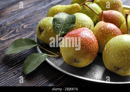 Metal plate with delicious ripe pears on table Stock Photo