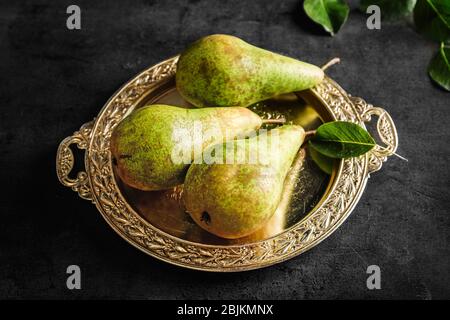 Ripe pears on ornate metal plate Stock Photo