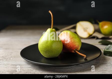Ripe pears on black plate Stock Photo