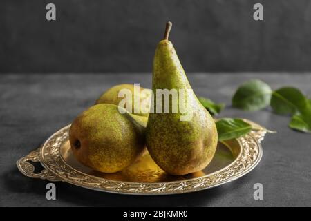 Ripe pears on ornate metal plate Stock Photo
