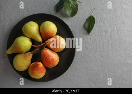 Ripe pears on black plate Stock Photo