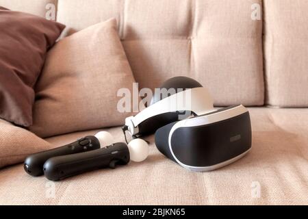 Moscow,Russia - April 12 2020 A playstation 4 VR headset together with a playstation 4 controller and two move controllers on a sofa, ready to start g Stock Photo