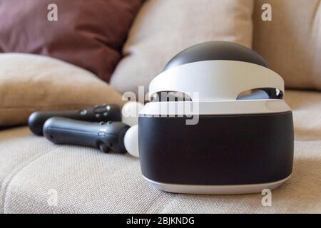Moscow,Russia - April 12 2020 A playstation 4 VR headset together with a playstation 4 controller and two move controllers on a sofa, ready to start g Stock Photo