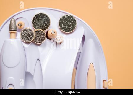 Set for home manicure with various nozzles on a beige background. Stock Photo