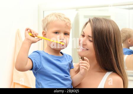 Mother teaching her child how to clean teeth Stock Photo
