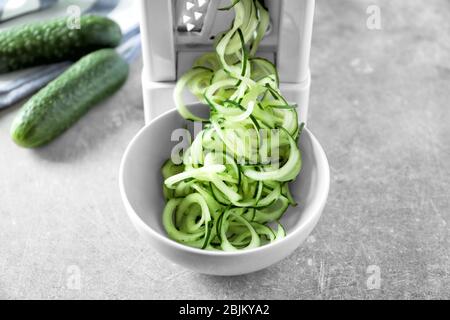Spiral vegetable slicer with cucumber spaghetti on table Stock Photo