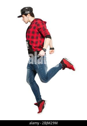 Young urban street dancer action. On white background. Modern dance, hip hop. He have only one foot on the floor, seen in profile. He wears a hat with Stock Photo