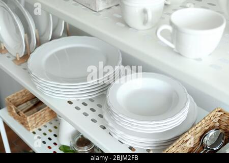 Different plates on shelf of storage stand Stock Photo
