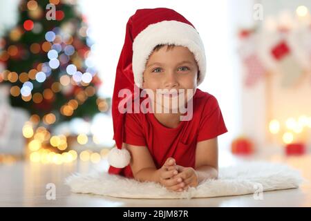 Cute little boy in Santa hat at home Stock Photo