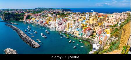 Panoramic view of the colorful houses and port of Corricella village in Procida island on a sunny summer day, Naples, Italy Stock Photo