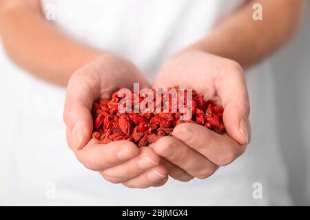 Woman holding red dried goji berries, closeup Stock Photo