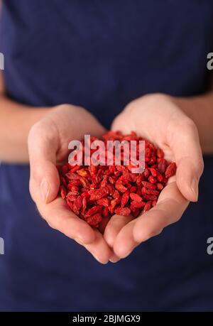 Woman holding red dried goji berries, closeup Stock Photo