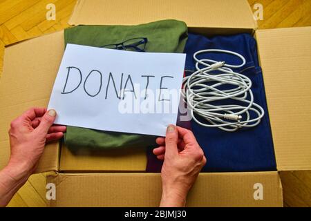 Donation concept. Donation box with donation clothes and accesories. Charity. Helping poor and needy people. Stock Photo