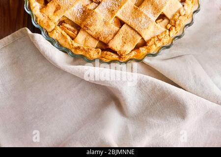 Layout or still life with home made apple pie on table covered with light tablecloth on kitchen at home or bakery. Top view with copy space Stock Photo