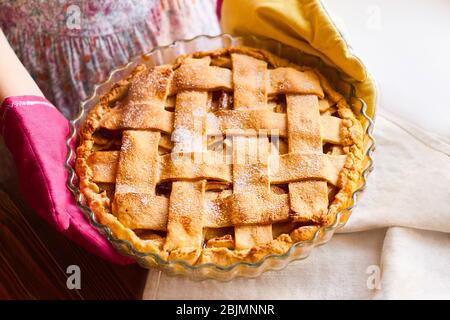 Layout or still life with home made apple pie on table covered with light tablecloth on kitchen at home or bakery. Woman serve home made apple tart on Stock Photo