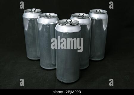 Simple 5 aluminium cans. Scratched, on black background. Pyramide Stock Photo