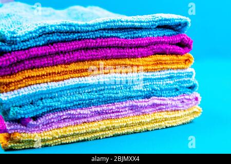 Multi-colored towels on a blue background. Pink, beige, yellow and blue flower towels. House order Stock Photo