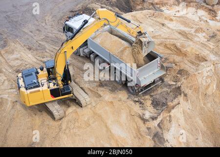 digger is loading sand on a truck Stock Photo